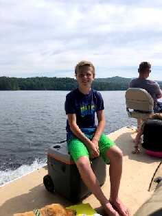 boy on a boat enjoying the ride to camp 